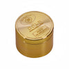مطحنة معدنية ذهبية دائرية بغطاء منقوش عليه "The Wand Over Gold Original Fancy Goods Made in The World Over.