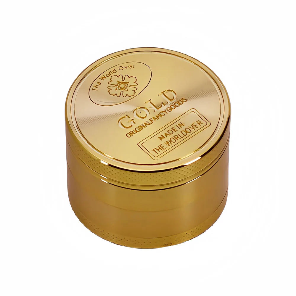 مطحنة معدنية ذهبية دائرية بغطاء منقوش عليه "The Wand Over Gold Original Fancy Goods Made in The World Over.