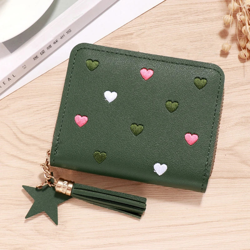 A dark olive green PU leather wallet with a zipper closure decorated with small pink and green heart shapes and attached to a