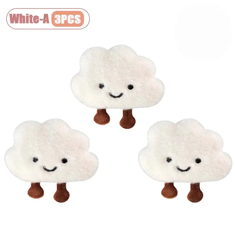 Three white cloud-shaped plush keychains or brooch pins.