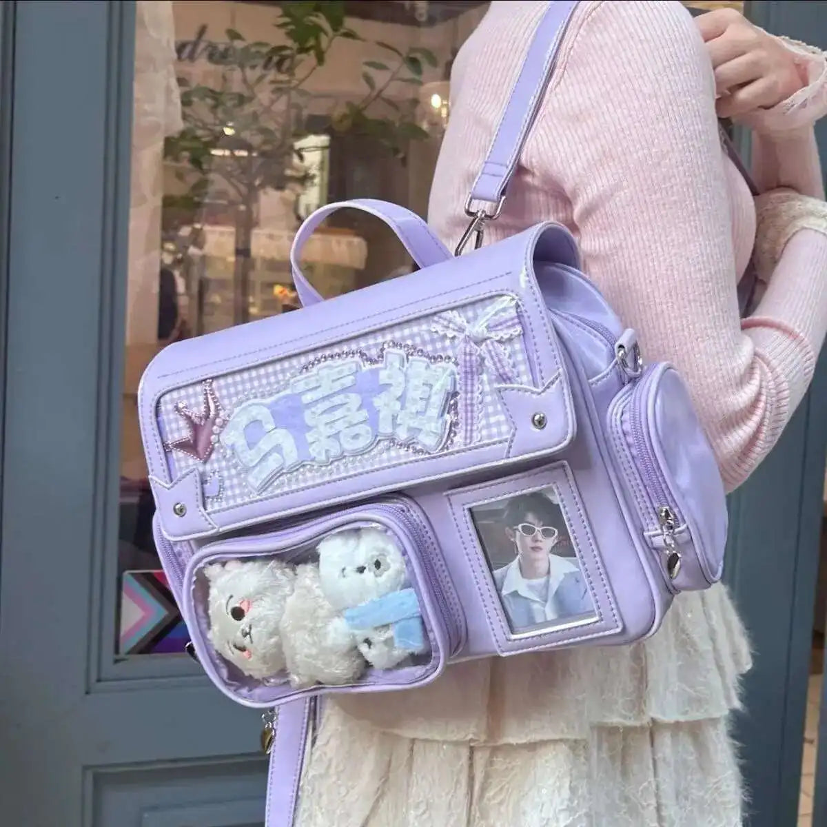 A light purple transparent PU crossbody bag with a decorative pattern and a small photo insert is carried by a person.