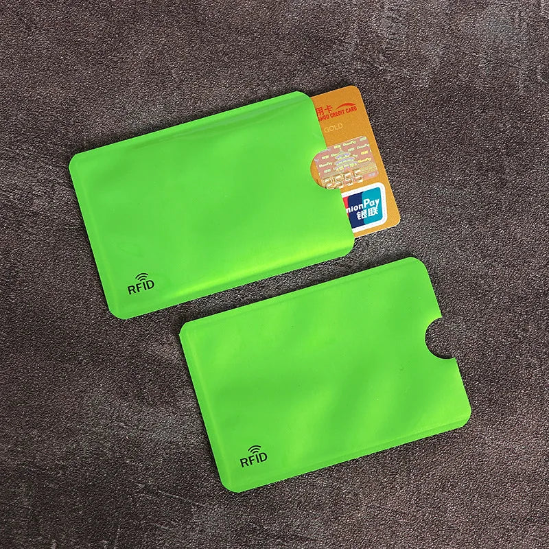 A bright lime green anti-scan card sleeve is shown next to a yellow credit card and an RFID protection card.
