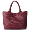 A deep burgundy handwoven vegan leather tote bag with a woven texture.