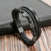 A black leather bracelet featuring multiple layers of beads, including tiger eye accents, resting on a dark surface.