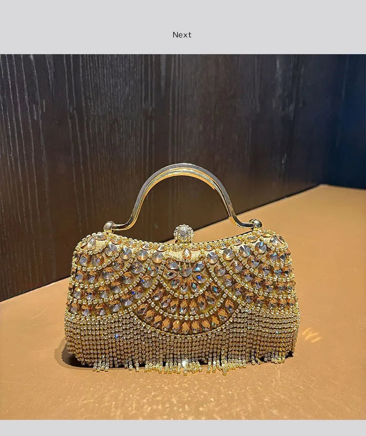 An elegant diamond rhinestone evening clutch bag with a golden tassel displayed on a brown surface.
