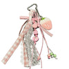 A pink strawberry bag charm keychain featuring lace, ribbons, and bead accents.