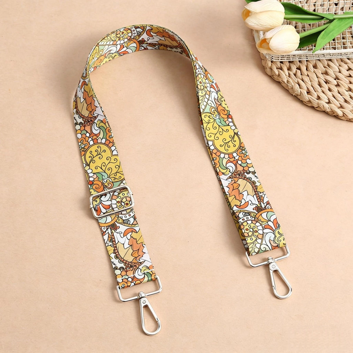 An adjustable bohemian printed crossbody strap featuring an orange and yellow floral pattern, displayed on a neutral backgrou