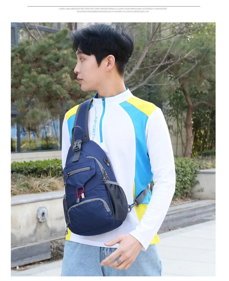 A young man wearing a white shirt and jeans holds a navy blue multi-functional nylon chest sling bag.