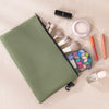 A green organizer tool kit bag is shown open, displaying various makeup and grooming tools like brushes and applicators.