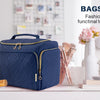 A navy blue bagsmart toiletry bag with a handle sits on a white surface next to various beauty products.
