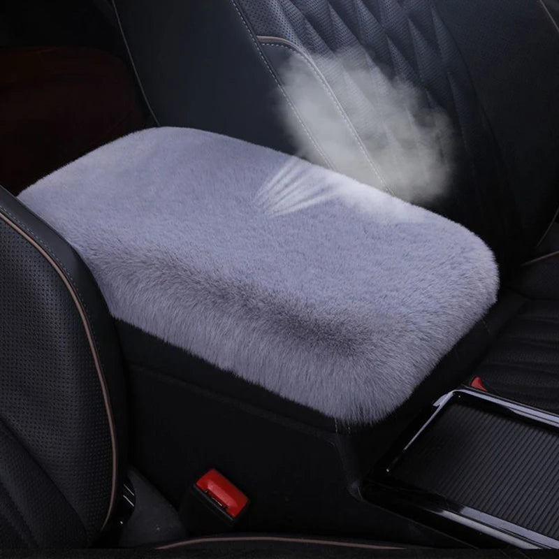 A plush gray car armrest cushion set is shown inside a black car interior.