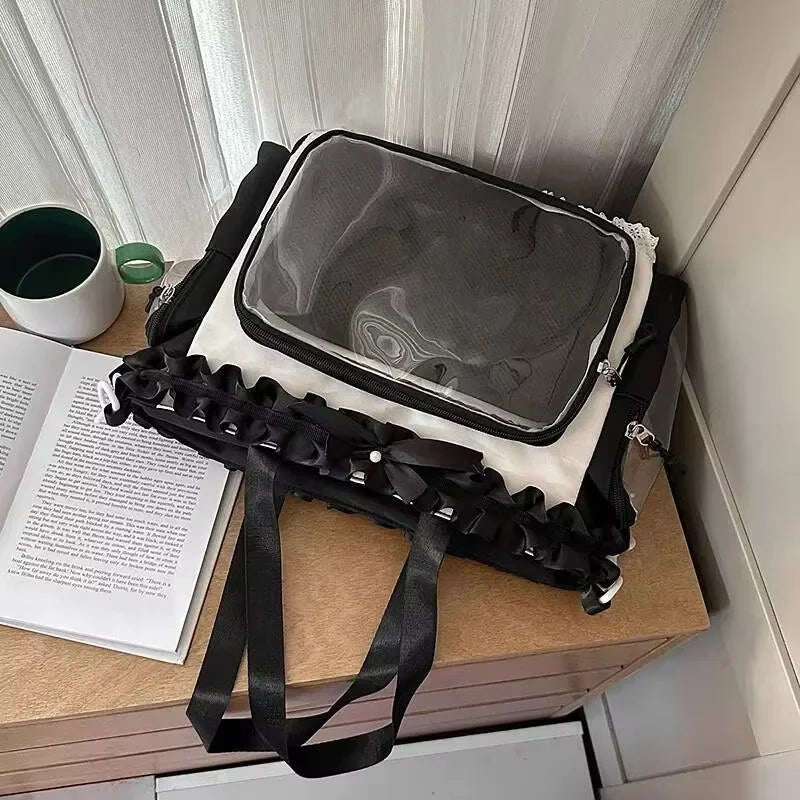 A transparent black shoulder tote bag with a white lining is displayed on a wooden surface next to some papers.