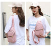 Eine Frau modelliert eine pinke wasserdichte Crossbody-Umhängetasche vor einem weißen Hemd.
