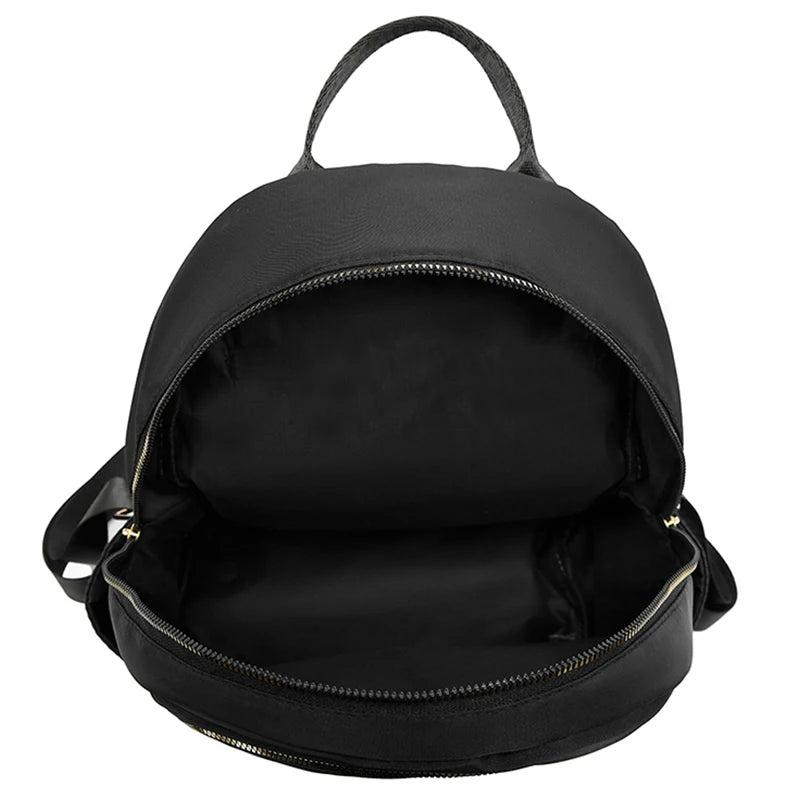 Schwarzer atmungsaktiver gesteppter Kunstleder-Daypack mit Topgriff und offener Klappe.
