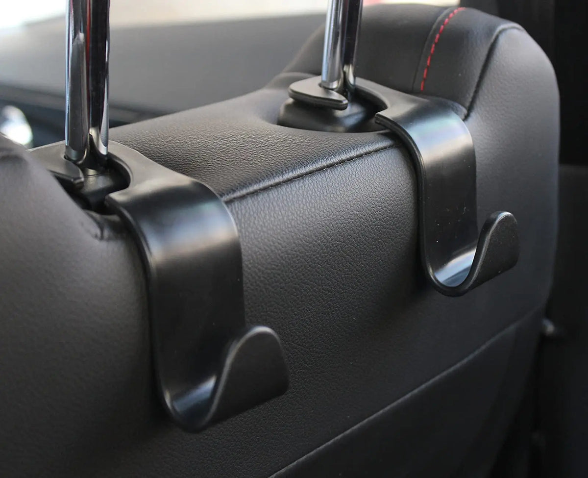 Close-up of black car seat back hooks used for trunk organization.