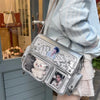 A silver transparent PU crossbody bag featuring a cat charm and a photo print, carried by a person.