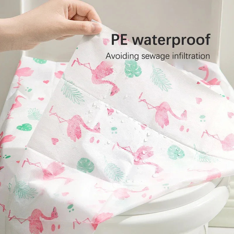 Pink and green patterned PE waterproof disposable toilet seat covers being held by a hand.