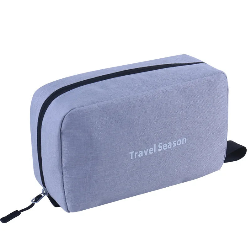 Sac de toilette de voyage suspendu gris clair imperméable avec garniture noire et sangle.