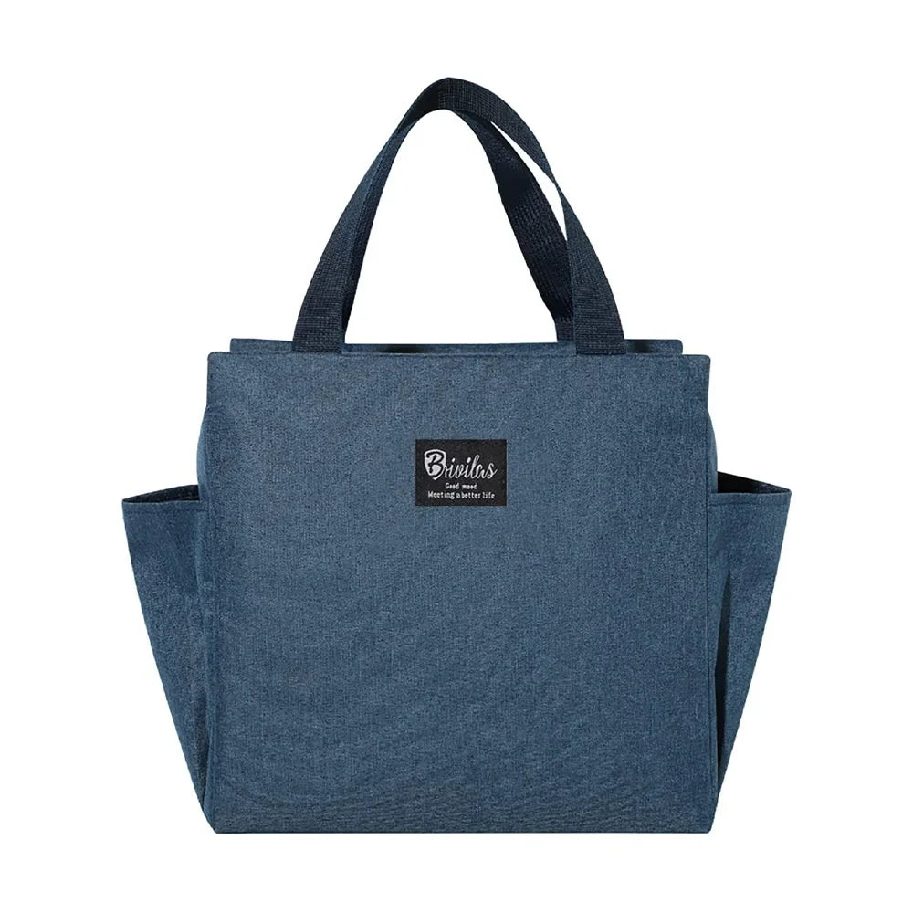 Una bolsa de almuerzo de lona aislada azul oscuro con asas de tela negra.