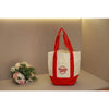 A white canvas bag with red handles and a red logo is displayed on a light surface.