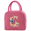 A pink insulated canvas lunch bag with a floral butterfly design and pink fabric handles.