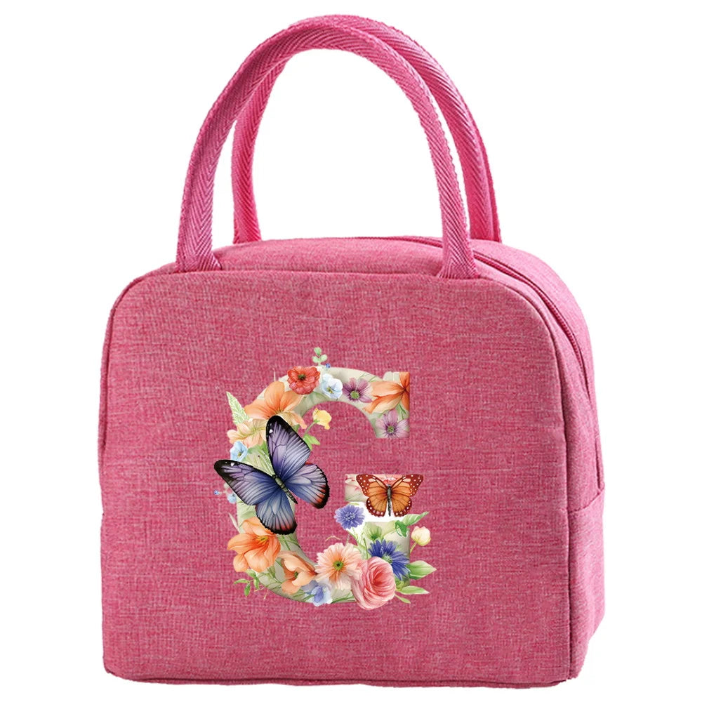 A pink insulated canvas lunch bag with a floral butterfly design and pink fabric handles.