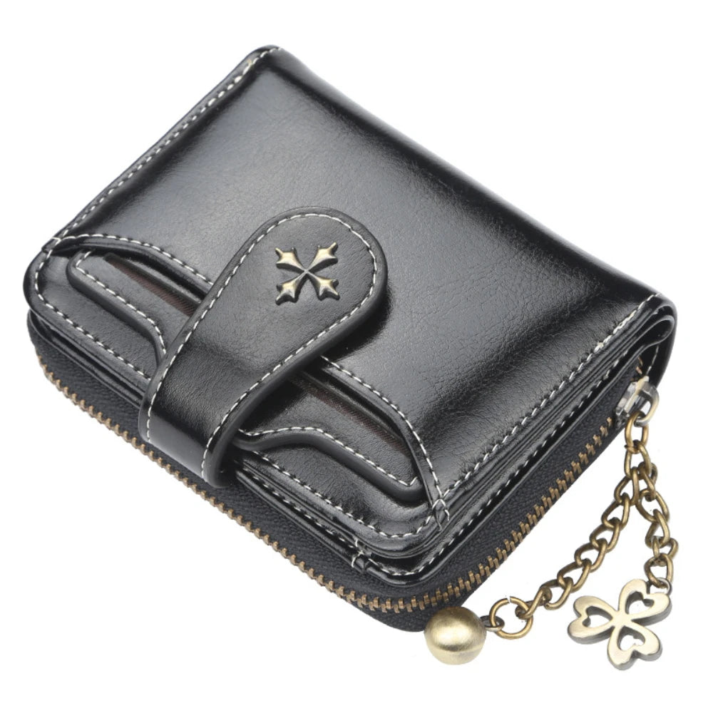 Black leather mini wallet with a gold clover charm and stitching