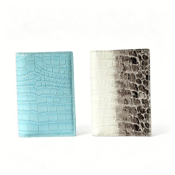 A pair of genuine leather passport holders featuring crocodile pattern in light blue and gray tones.