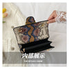 Interior view of an elegant retro crossbody bag with a patterned exterior and gold hardware.