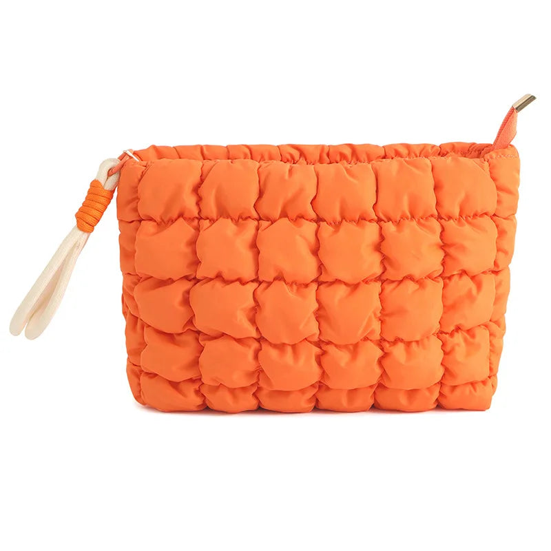 Orange quilted puffer makeup bag with a fabric strap