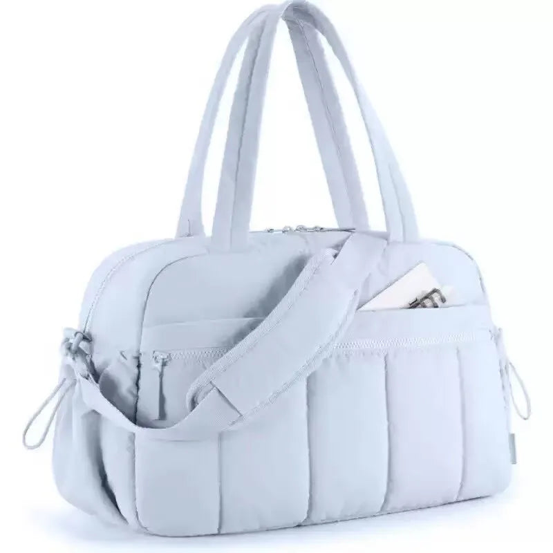 A light gray versatile large capacity travel and fitness bag with white handles.