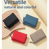 Colección de carteras pequeñas de cuero natural y coloridas en tonos negro, azul, rojo y gris.