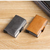 A pair of premium double layer ID card holder wallets in gray and tan leather resting on a light wooden surface.