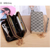 Cartera con cremallera de cuero sintético gris abierta, mostrando un smartphone y una cartera a juego estampada.