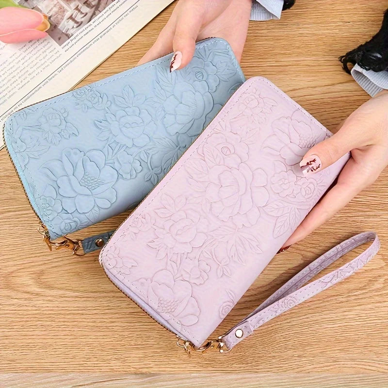 Dos billeteras de tarjetas de cuero PU con relieve y flores en azul claro y rosa sobre una superficie de madera.