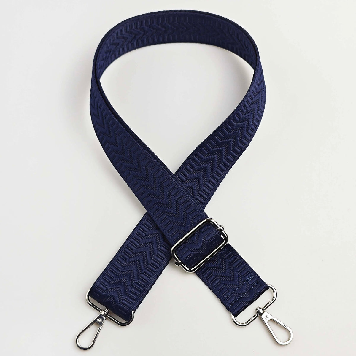 Navy blue adjustable handbag strap with an arrow jacquard pattern
