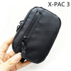 Pochette utilitaire noire X-PAC 3 pour clés et essentiels tenue par une main.