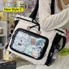 A white transparent shoulder tote bag with black trim and floral accents is displayed next to various small items.