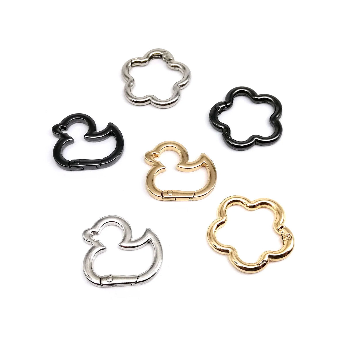 Collection de cinq clips en métal en forme de fleurs d'oie, finis argent et noir.