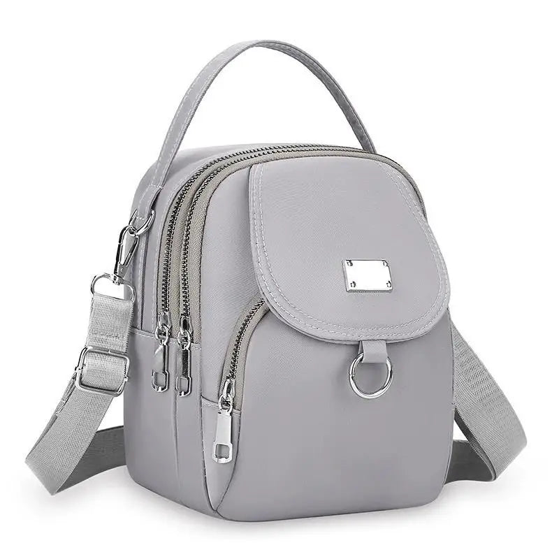 Sac bandoulière floral gris clair et durable avec fermeture éclair et sangle réglable.