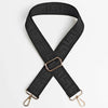 Black adjustable crossbody bag strap featuring a textured maze pattern and gold-toned hardware.