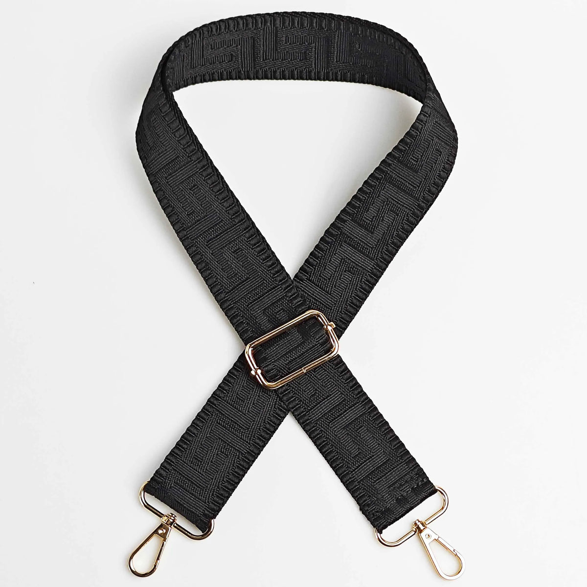 Black adjustable crossbody bag strap featuring a textured maze pattern and gold-toned hardware.