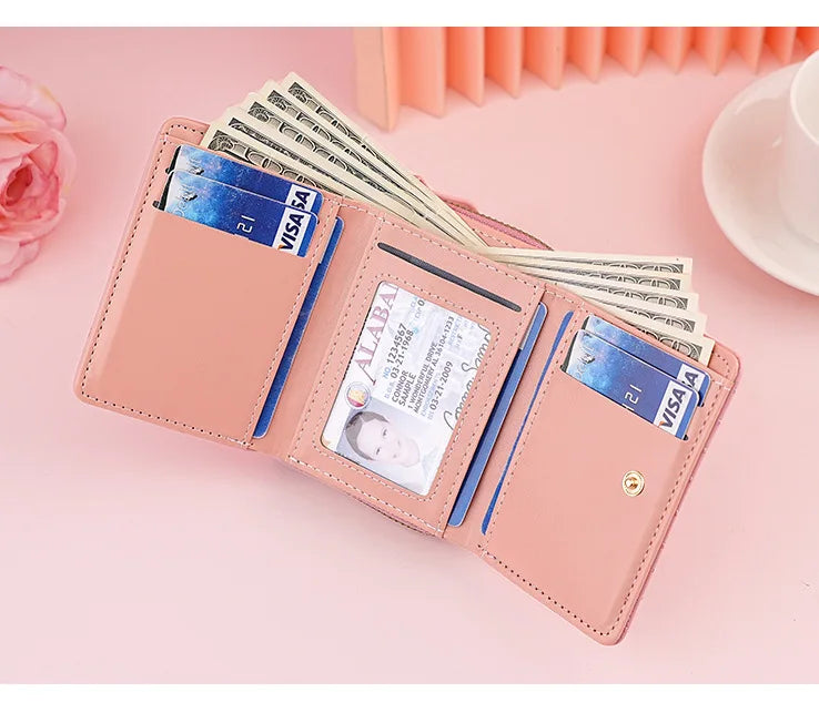 A pink PU leather women's wallet displaying various credit cards and cash inside.