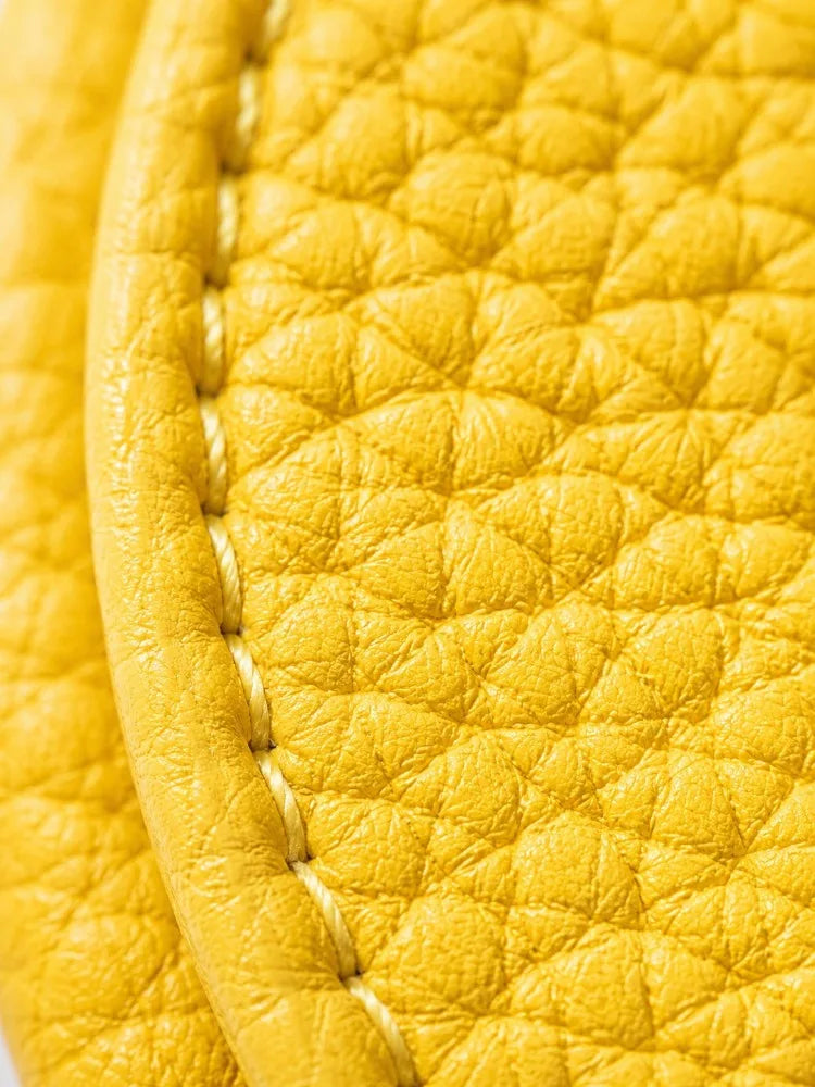Close-up of a yellow fruit-shaped PU leather coin purse keychain with visible stitching.
