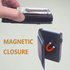 A hand holds a black slim aluminum wallet with a magnetic closure, showing cash inside.