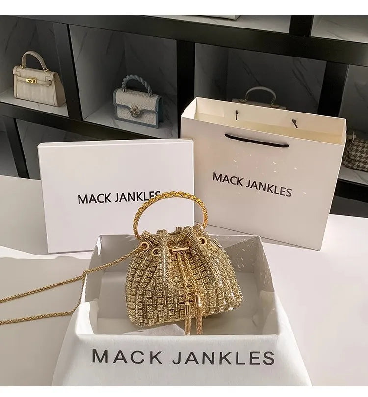 A gold crystal-embellished evening clutch with a chain displayed in a white box.