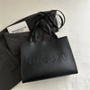 A black tote bag is shown next to a white card labeled Metaphorical Concepts on a white surface.