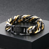 A chunky Cuban link bracelet featuring alternating black and gold links displayed on a dark surface.