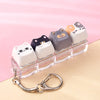 A set of five cute cat-shaped keycaps or fidget toys in various pastel colors displayed on a clear plastic tray.