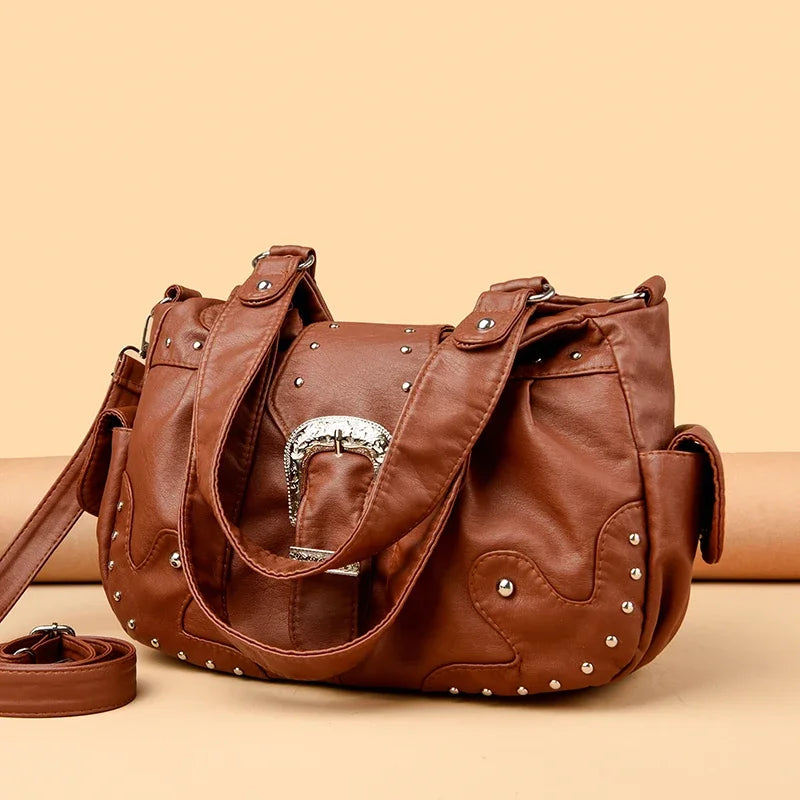Braune Vintage Soft PU Lederhandtasche mit silberner Hardware auf beigem Untergrund.